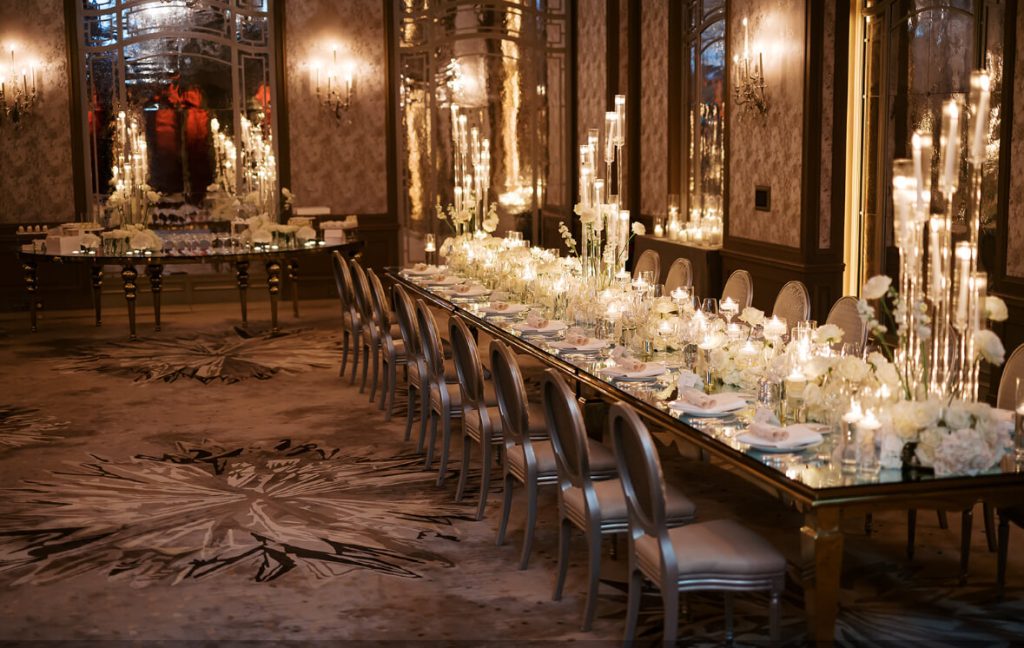 Event rental in Paris Elegant wedding decor setup featuring crystal chandeliers, gold chairs, floral vases, and candlelight — available for rental in Paris.